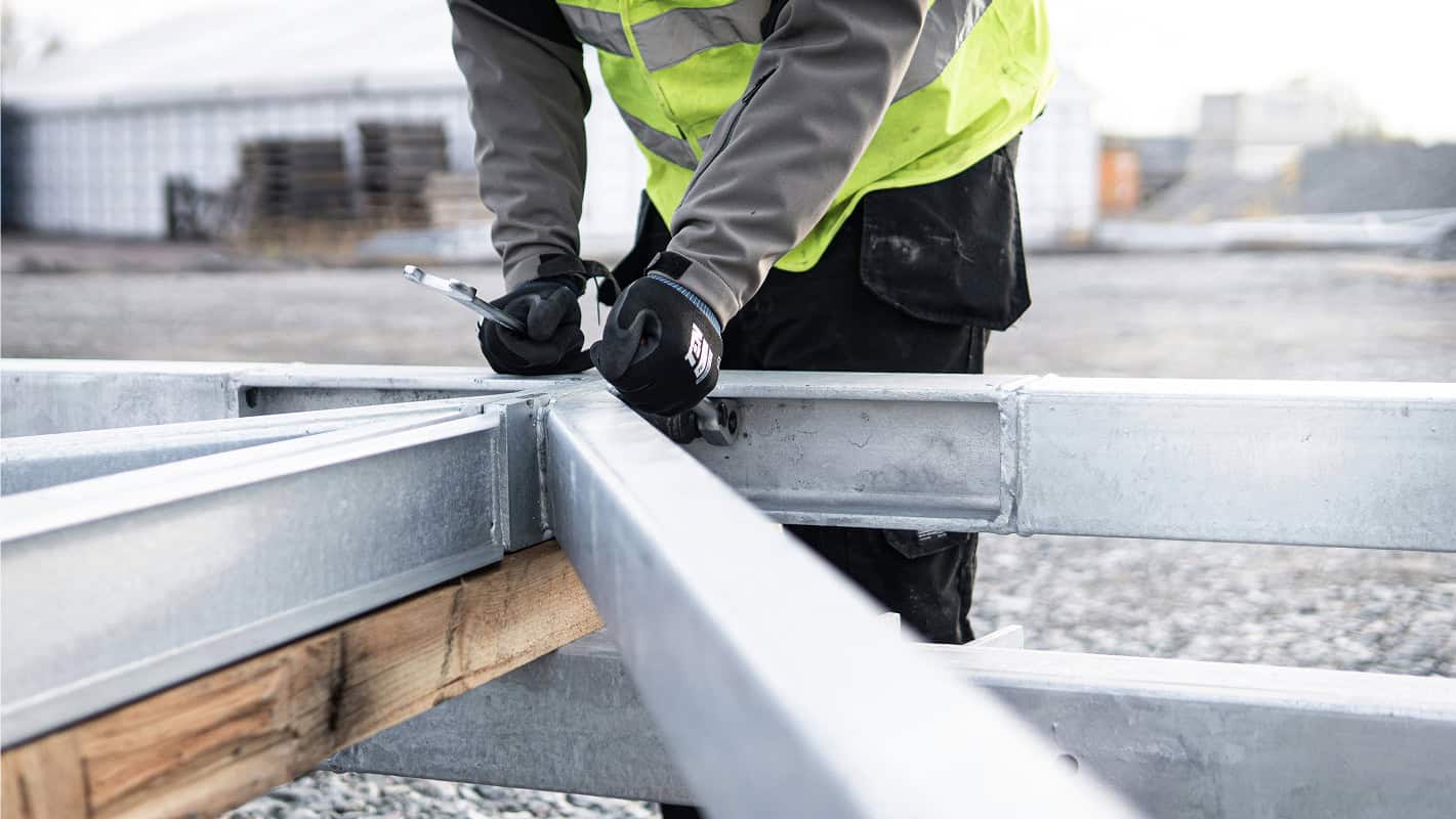 Vy rakt ner genom ett modernt trapphus med svarta räcken och trädetaljer, där trapporna bildar ett geometriskt mönster.